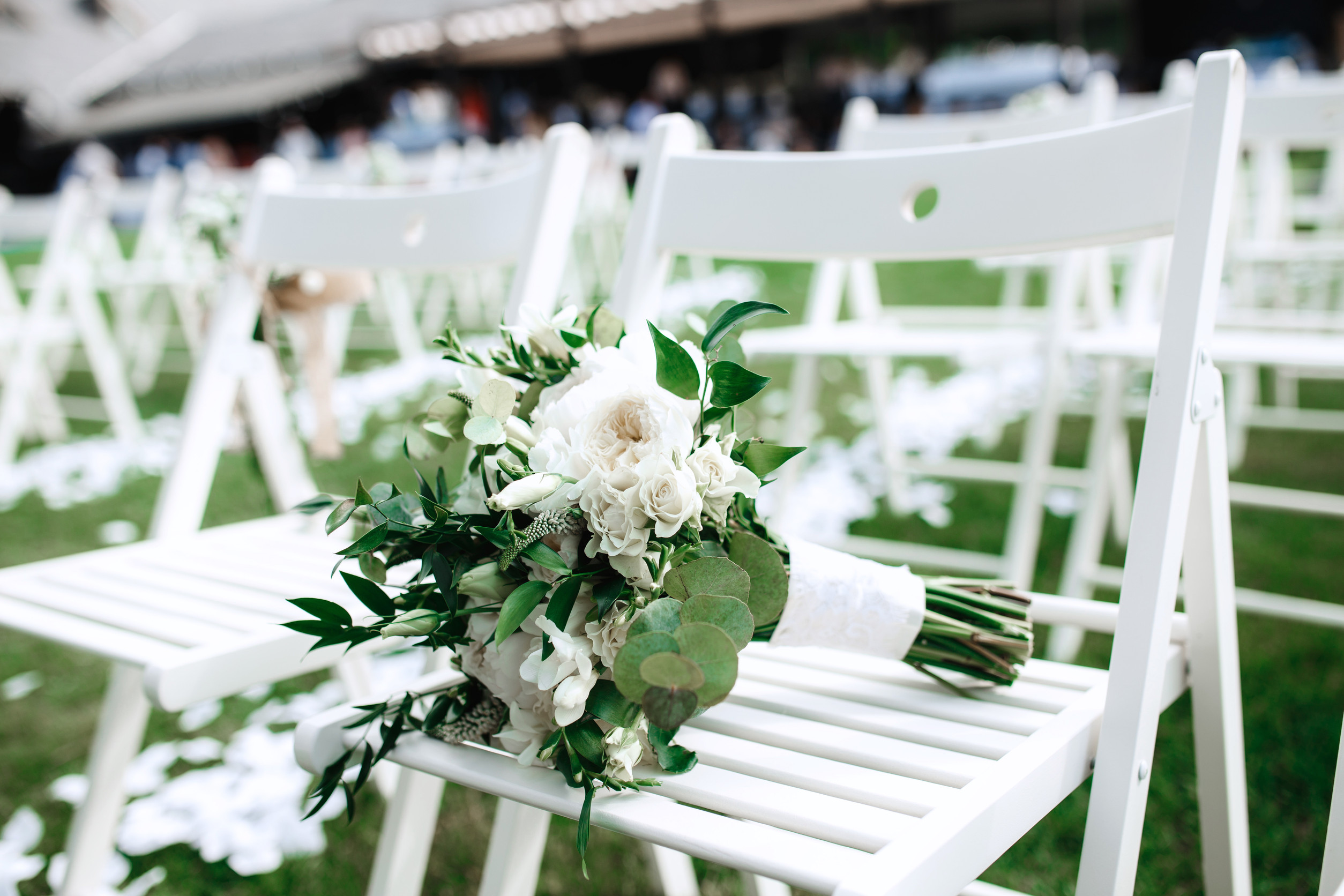 White wedding flowers attached to ceremony chairs at outdoor wedding setup at Lezar Opstal Heidelberg Gauteng