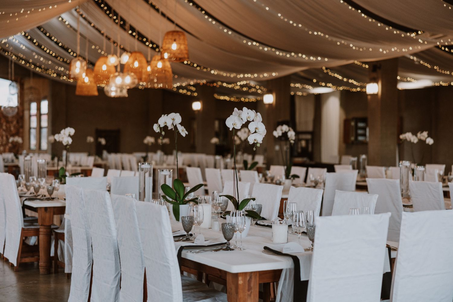 Romantic wedding reception décor with drapes and lights inside venue at Lezar Opstal Heidelberg Gauteng