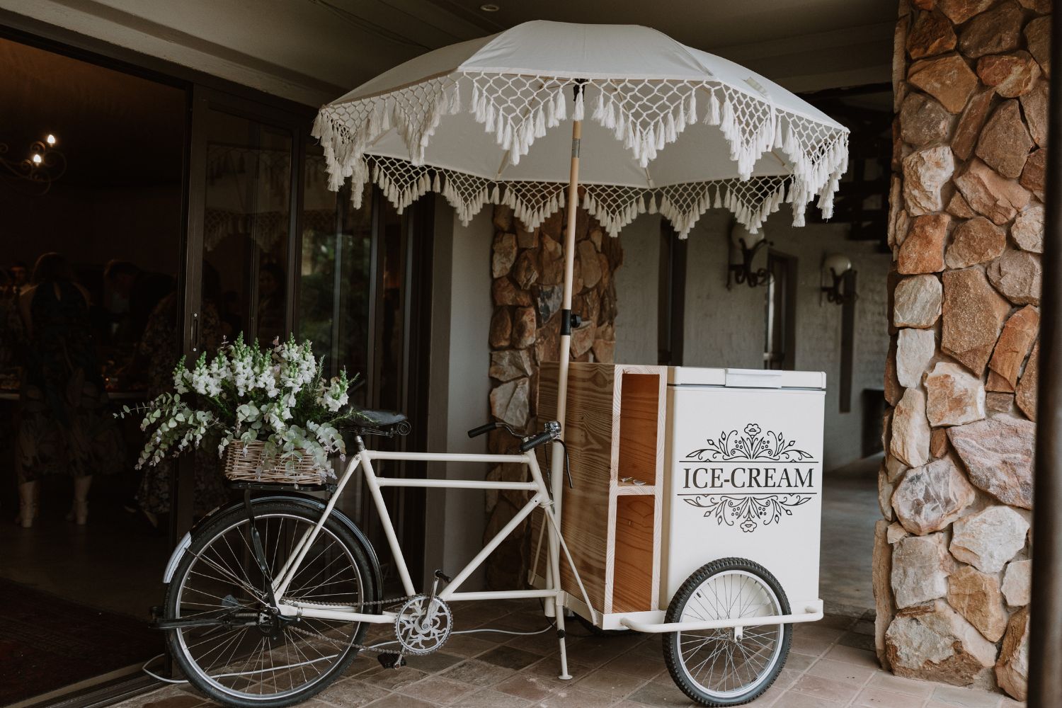 Ice cream cart with umbrella set up at a wedding reception, offering guest refreshments at Lezar Opstal Heidelberg