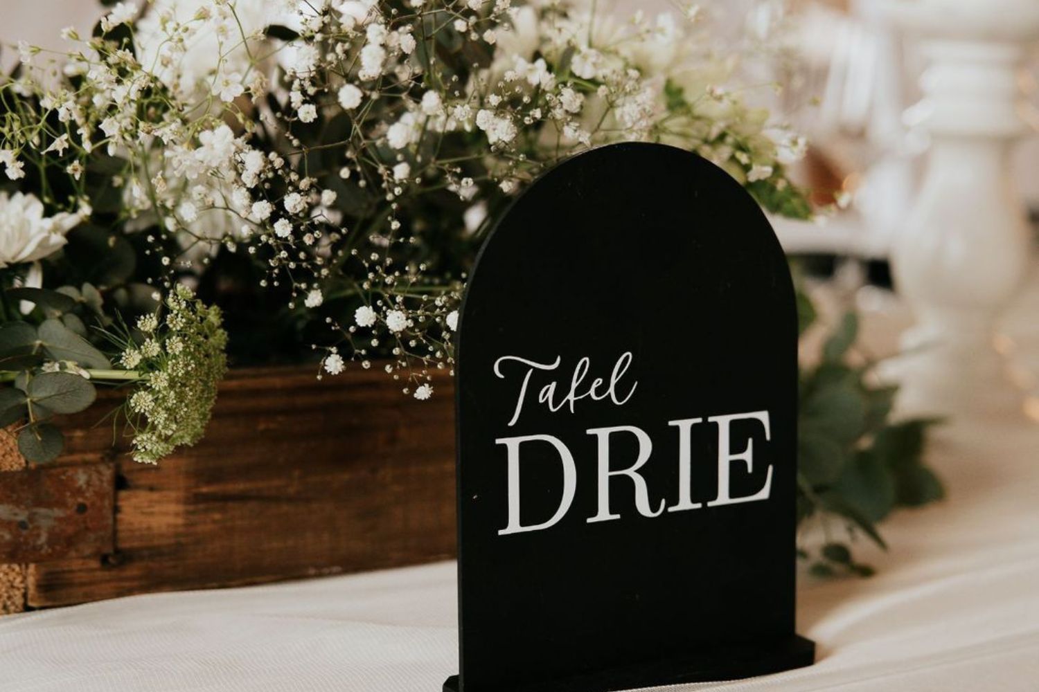 Close-up of elegant table number centrepiece placed on a decorated wedding reception table at Lezar Opstal Heidelberg