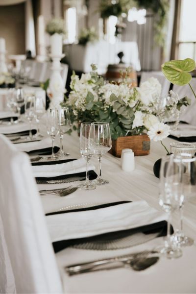 Close-up of white elegant wedding reception table décor with refined floral styling and classic table settings at Lezar Opstal Heidelberg